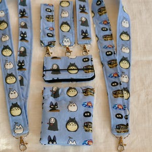 May include: Five blue and white patterned lanyards with gold clasps and a matching blue and white patterned wallet and pouch.