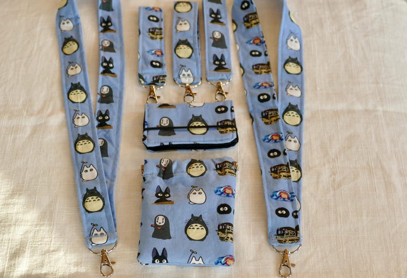 May include: Five blue and white patterned lanyards with gold clasps and a matching blue and white patterned wallet and pouch.