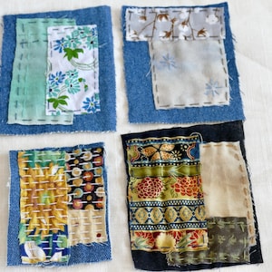 May include: Four small square fabric patchwork coasters with different patterns and colors. The coasters are made of denim and have a variety of fabrics sewn on top. The fabrics include floral patterns, geometric patterns, and solid colors.