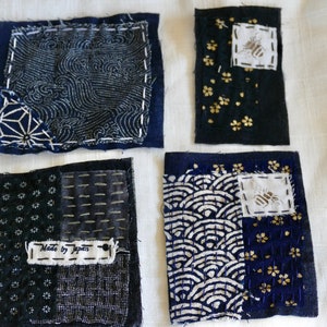 May include: Four blue fabric squares with different patterns and a white label that says "Made by Japan".