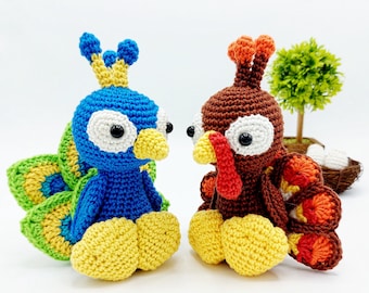 May include: Two crocheted stuffed animals, a blue peacock and a brown turkey, are sitting side-by-side. The peacock has a yellow crown and a green and yellow tail. The turkey has a red wattle and a red and orange tail.
