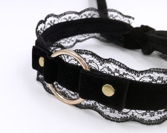 May include: Black velvet choker with a delicate lace trim and a gold metal ring.