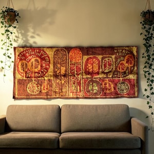 May include: A rectangular wall hanging featuring a rich, textured tapestry in shades of deep red, burgundy, and gold. The fabric displays a repeating pattern of circular and rectangular motifs with intricate, stylised botanical and geometric designs.