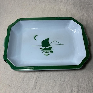 May include: Rectangular white tray with a green border and handles. The tray features a green illustration of a sailboat on water with a crescent moon in the sky. The tray is likely made of enamel.