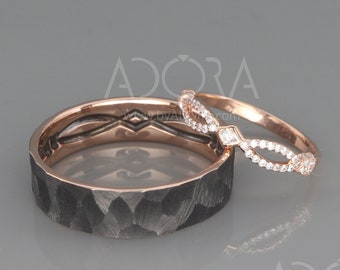 Puede incluir: Un par de anillos de boda. La banda del hombre es una banda ancha, negra con un acabado martillado. La banda de la mujer es una banda delgada de oro rosa con un delicado diseño de diamantes.
