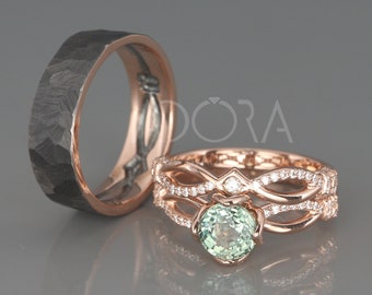 May include: A set of wedding bands featuring a black hammered band and a rose gold band with a green gemstone and diamond accents. The rose gold band has a delicate, interwoven design.