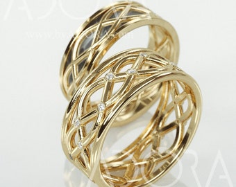 May include: Two gold wedding bands with a Celtic knot design. The band on the left has a smooth finish, while the band on the right has small diamonds set into the design.