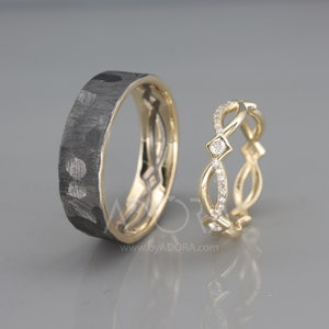 Pode incluir: Um par de alian&ccedil;as de casamento. A alian&ccedil;a &agrave; esquerda &eacute; feita de metal preto com textura martelada. A alian&ccedil;a &agrave; direita &eacute; feita de ouro amarelo com um design delicado e pequenos diamantes.