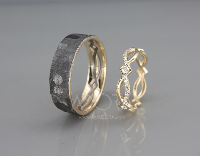 Pode incluir: Um par de alian&ccedil;as de casamento. A alian&ccedil;a &agrave; esquerda &eacute; feita de metal preto com textura martelada. A alian&ccedil;a &agrave; direita &eacute; feita de ouro amarelo com um design delicado e pequenos diamantes.