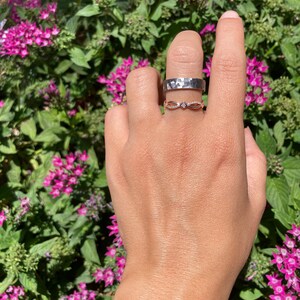 Pode incluir: Duas alian&ccedil;as de prata em um dedo. A alian&ccedil;a superior &eacute; uma banda larga com textura martelada. A alian&ccedil;a inferior &eacute; uma banda delicada com um design em forma de diamante.