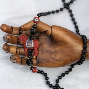 Beautiful vintage black beaded necklace with two round enameled cloisonné beads and a large carved cinnabar and cloisonné horse.