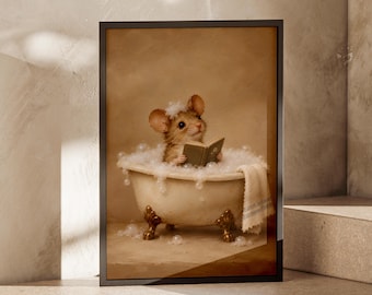 Può includere: Una stampa artistica incorniciata raffigurante un topo marrone seduto in una vasca da bagno bianca con piedini, piena di bolle di sapone. Il topo ha un po' di schiuma sulla testa e tiene in mano un piccolo libro verde. Un asciugamano bianco pende.