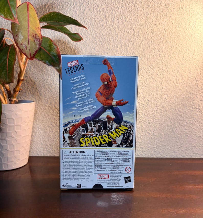 May include: A Marvel Legends action figure box featuring Spider-Man in a dynamic pose. The box is predominantly blue with a cityscape backdrop and the Spider-Man logo. The figure is red and blue.