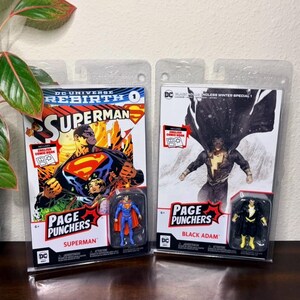 May include: Two Page Punchers action figure sets. One features Superman with a comic book cover, and the other features Black Adam with a comic book cover. Both figures are in clear plastic packaging.
