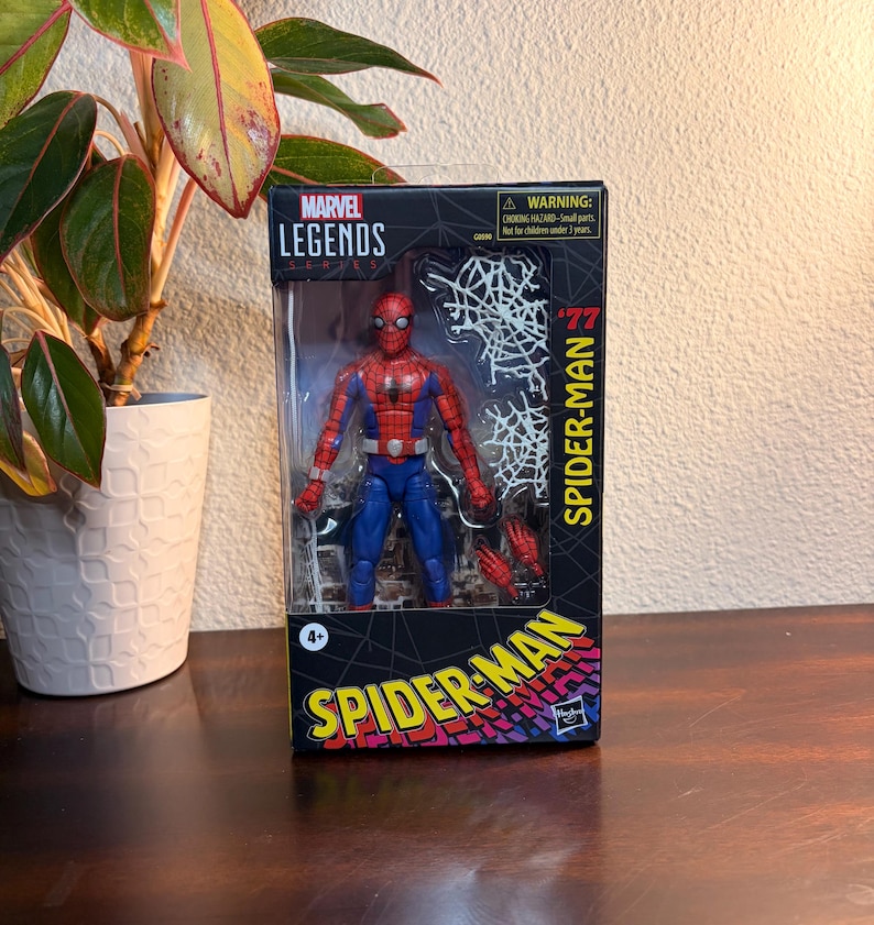 May include: A Marvel Legends Spider-Man action figure in its original packaging. The figure is in a classic red and blue costume, with a web design on the packaging. The box features the text "Spider-Man" and "Marvel Legends Series".