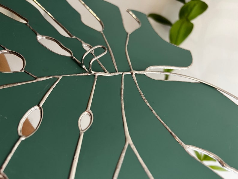 Detailed copper foil lines on stained glass leaf mirror