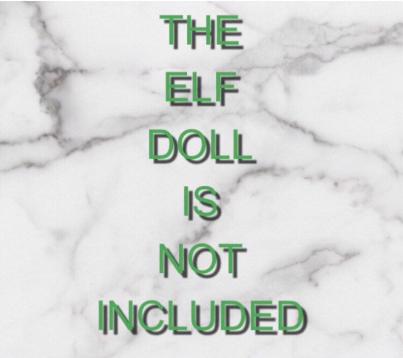 May include: Text on a white marble background reads "THE ELF DOLL IS NOT INCLUDED" in green letters with a black shadow. The text is centered and takes up most of the image.