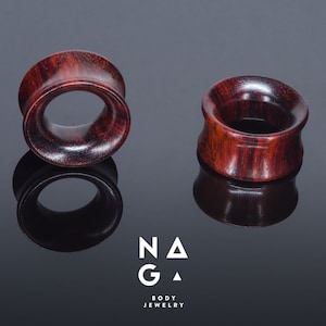 May include: Two wooden ear gauges, one on each side of the image, are a dark reddish brown colour with a natural wood grain pattern.