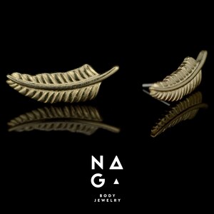 May include: A pair of gold feather earrings. The earrings are small and delicate, and they have a simple, elegant design.