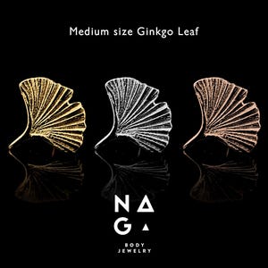 May include: Three medium-sized Ginkgo leaf body jewelry pieces in gold, silver, and rose gold. The leaves are detailed with textured veins, set against a black background. The brand logo "NAGA BODY JEWELRY" is at the bottom.