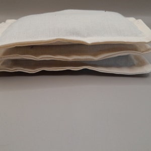 Puede incluir: Tres bolsas de tela blanca apiladas una encima de la otra. Las bolsas est&aacute;n hechas de una tela blanca suave y tienen un dise&ntilde;o simple y limpio.