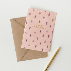 Tarjeta navideña con estrellas beige y letras doradas
