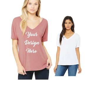 May include: Two women wearing v-neck t-shirts. The shirt on the left is a dusty rose color with the text "Your Design Here" printed on the front. The shirt on the right is white.