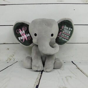 Puede incluir: Peluche de elefante de felpa gris con orejas bordadas. Una oreja dice "Ava Patricia" y la otra oreja dice "3 lbs 7 oz Jan 8th 2018 1:11 P.M. 17 inches".