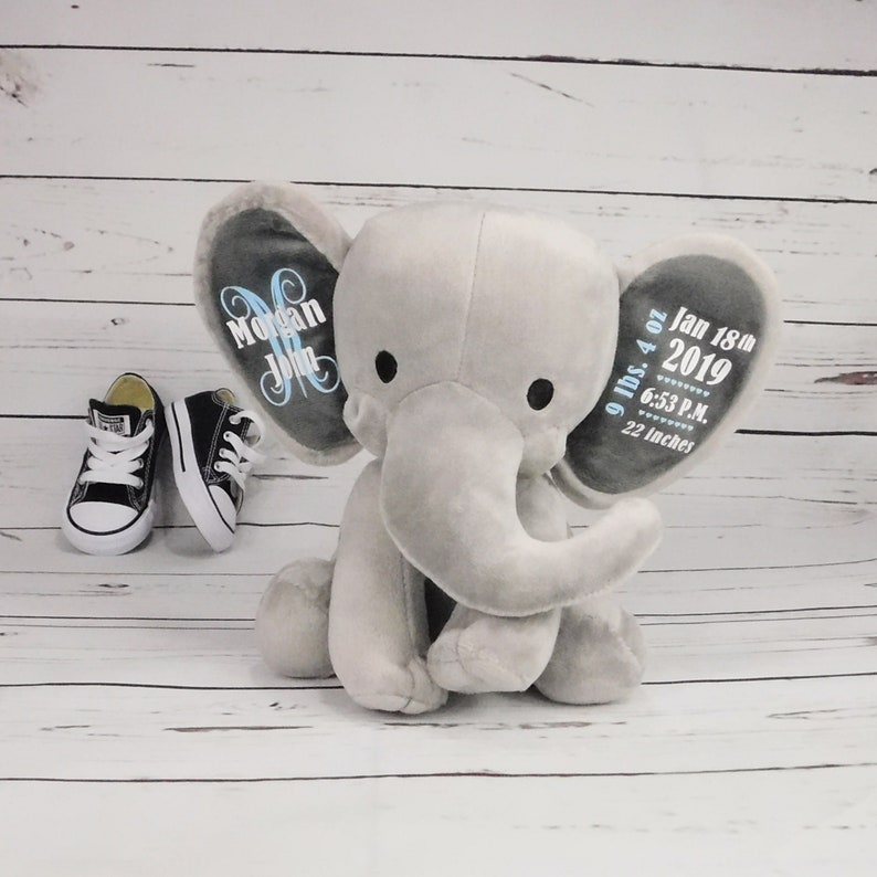 Puede incluir: Juguete de peluche de elefante gris para beb&eacute; con orejas personalizadas. Una oreja dice "Morgan John" y la otra oreja dice "9 lbs 4 oz Jan 18th 2019 6:53 P.M. 22 inches".