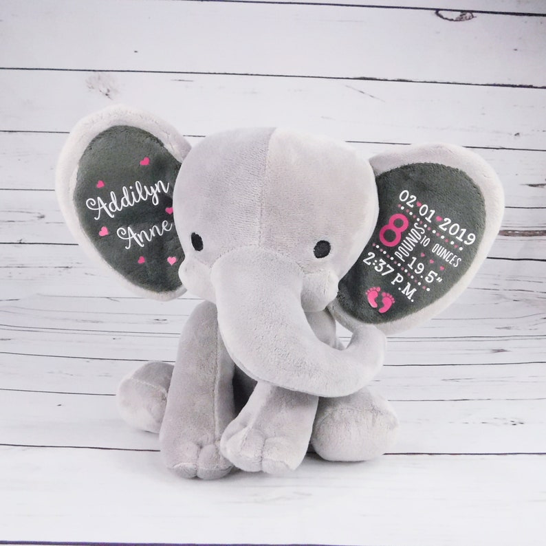 May include: Gray plush elephant stuffed animal with embroidered details. One ear reads "Addilynn Anne" with pink hearts. The other ear reads "02.01.2019 8 pounds 10 ounces 19.5" 2:37 P.M."