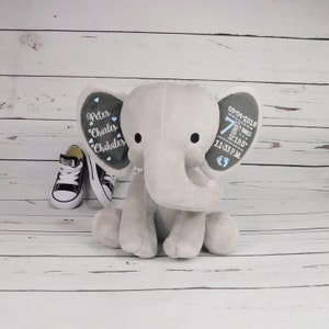 May include: Gray plush elephant baby toy with embroidered details on the ears. One ear says "Peter Charles Chakalos" and the other ear says "09-04-2018 7 pounds 19.5 inches 11:33 PM".