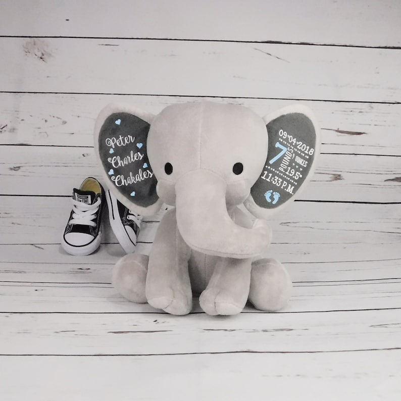 May include: Gray plush elephant baby toy with embroidered details on the ears. One ear says "Peter Charles Chakalos" and the other ear says "09-04-2018 7 pounds 19.5 inches 11:33 PM".