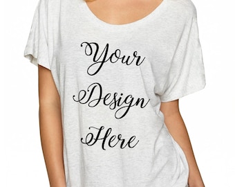 Op de afbeelding: Een wit, loszittend T-shirt met een ronde hals. Het shirt heeft de tekst "Your Design Here" in zwarte cursieve letters op de voorkant.