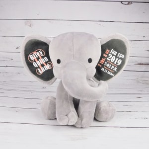 Puede incluir: Elefante de peluche gris con orejas bordadas. Una oreja dice "Riley Quinn Lane" y la otra oreja dice "7 lbs. 8 oz Jan 15th 2019 7:02 P.M. 19.75 Inches".
