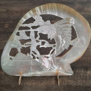 Schelp, : zwaardvis gegraveerd op pareloester