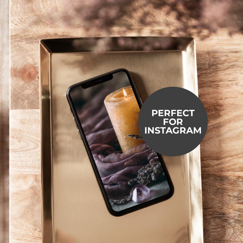 May include: A lit yellow candle on a smartphone screen, displayed on a gold-colored tray. The screen shows a close-up of the candle with a purple cloth and other objects. The tray sits on a wooden surface. Text on the image says "PERFECT FOR INSTAGRAM".