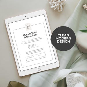 Pu&ograve; includere: Un tablet digitale mostra un modulo di autorizzazione foto e video con un logo e caselle di controllo. Il modulo &egrave; su sfondo bianco con testo nero. Un cerchio grigio scuro con la scritta "CLEAN MODERN DESIGN" &egrave; a destra. Il tablet &egrave; su un panno verde chiaro.
