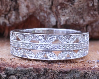 May include: A silver band ring with a double row of small diamonds set in a delicate leaf pattern.
