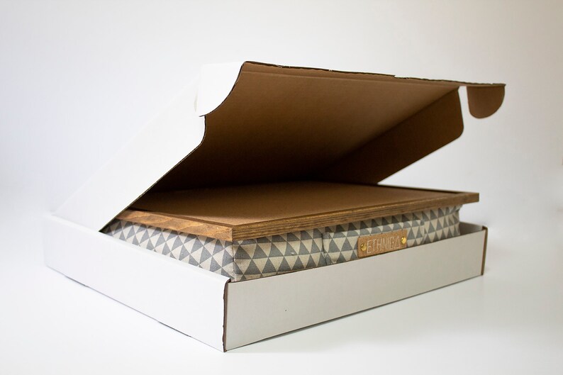 Pu&ograve; includere: Una scatola di cartone bianca con il lembo superiore aperto, che rivela una scatola di stoffa con motivo grigio e bianco con un coperchio in legno. La scatola di stoffa ha un'etichetta in pelle marrone con la parola "ETERNAL" stampata su di essa.
