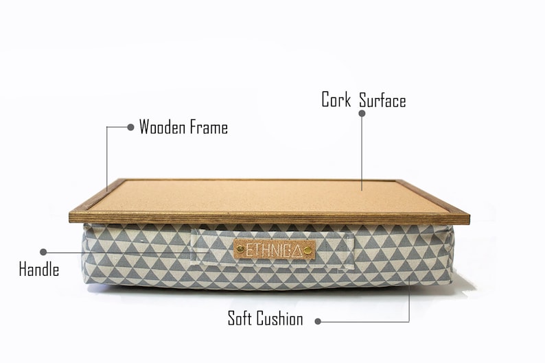 Pu&ograve; includere: Un cuscino con motivo grigio e bianco con una cornice in legno e una superficie in sughero. Il cuscino ha una maniglia e il testo "ETHNICA" sul davanti.