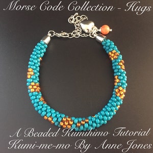 May include: A turquoise and gold beaded bracelet with a silver clasp and a heart charm. The bracelet is made using the kumihimo technique. The text "Morse Code Collection - Hugs" and "A Beaded Kumihimo Tutorial Kumi-me-mo By Anne Jones" is visible in the image.