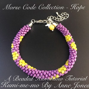 Peut inclure: Un bracelet en perles violet et jaune avec un fermoir argenté et un petit charme. Le bracelet est réalisé à l'aide de la technique du kumihimo. Le texte "Morse Code Collection - Hope" et "A Beaded Kumihimo Tutorial Kumi-me-mo By Anne Jones" est visible sur l'image.