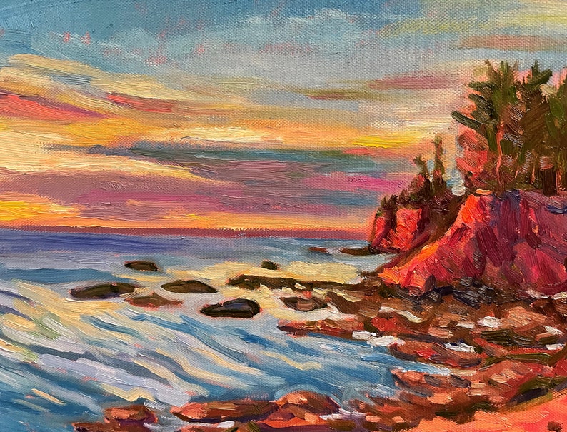 Puede incluir: Una pintura de una costa rocosa con un bosque de pinos en un acantilado al atardecer. El cielo es una mezcla vibrante de rosa, naranja y amarillo. El agua es de un azul profundo con olas blancas que rompen en las rocas.