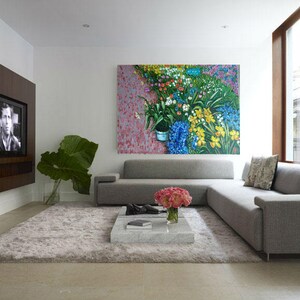 May include: A gray sectional sofa with a floral painting above it. The sofa is in a modern living room with a large window and a flat screen TV on the wall.