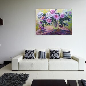 May include: A painting of a bouquet of pink and white peonies in a vase on a table. The flowers are arranged in a loose, natural style, and the vase is a simple, clear glass.