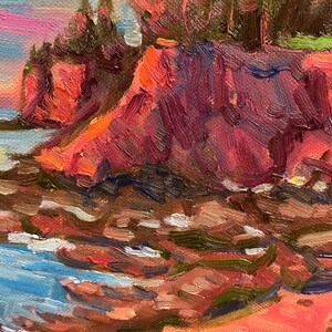 Puede incluir: Una pintura de una costa rocosa con un acantilado rojo en el fondo. El agua es azul y el cielo es rosa y morado. La pintura est&aacute; hecha en un estilo suelto e impresionista.