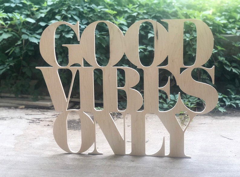May include: Wooden sign with the words "Good Vibes Only" cut out in a decorative font.