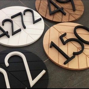 May include: Four wooden signs with black numbers on them. The numbers are 4272, 150, 22, and 497. The signs are all different colors and have a chevron pattern.