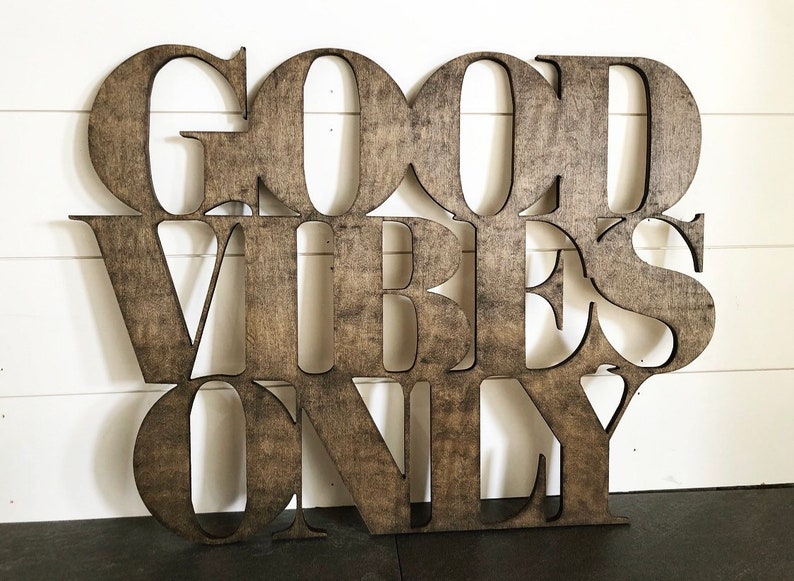 May include: Wooden sign with the words "Good Vibes Only" in a brown stain finish.