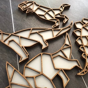 May include: Four wooden dinosaur wall decorations in a geometric style. The dinosaurs are made of layered wood and are painted white. They are arranged in a cluster on a gray tiled surface.